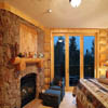 Log mantle above fireplace in log home bedroom